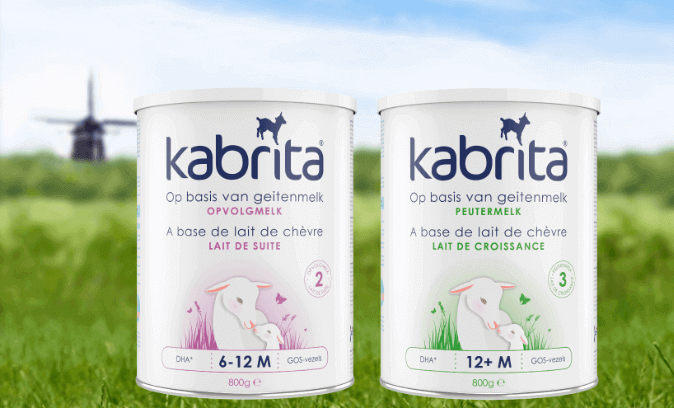 One purple and one green package of Kabrita goatmilk with mill in background 